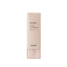 Load image into Gallery viewer, HEIMISH Artless Glow Tinted Cream in Shine Beige is a lightweight, multi-functional tinted cream that provides natural coverage with a radiant glow. Formulated with Niacinamide and Pearl Extract, it brightens the complexion while offering SPF protection against harmful UV rays. Enriched with botanical extracts like Rosa Canina and Thyme, it nourishes and soothes the skin, leaving it smooth and hydrated. This tinted cream blends effortlessly, enhancing your skin’s natural tone with a subtle glow. Perfect for